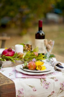 Şarap ve meyve bahçesinde öğle yemeği. Romantik bir akşam yemeği açık havada. Sonbahar yaprakları çiçek. Güzel masa scrapbooking.