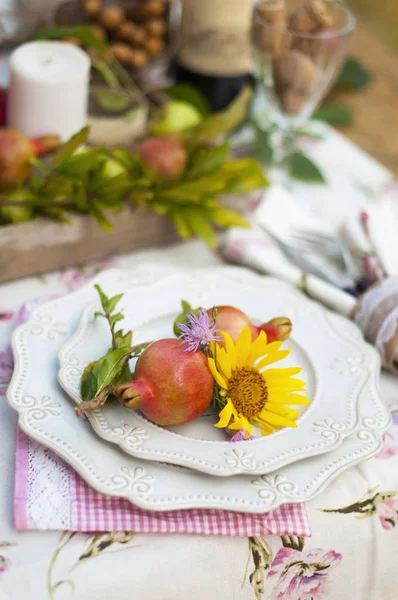 Романтична вечеря в осінньому саду, обстановка столу для гарної вечері. Вино, фрукти, гранат і квіти. Пікнік під відкритим небом . — стокове фото