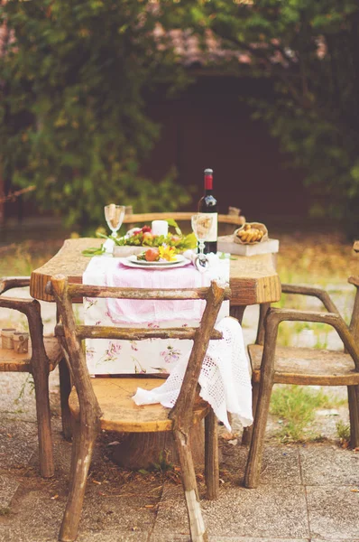 Pranzo in giardino con vino e frutta. Cena romantica all'aria aperta. Foglie autunnali di fiori. Bella tabella scrapbooking. Foto vintage . — Foto Stock