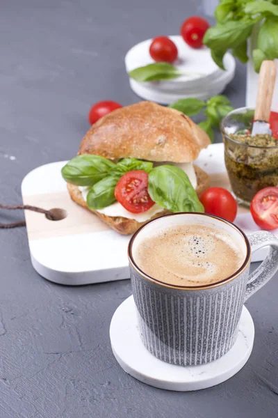 Ароматный утренний кофе и сэндвич с моцареллой и базиликом на завтрак. Вкусная и здоровая еда. Итальянский обед. Копирование пространства — стоковое фото