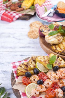 Piknik ızgara gıda ile. Farklı sebze ve meyve ızgara ve deniz ürünleri, karides. Lezzetli yaz öğle yemeği. Üstten görünüm. Kopya alanı