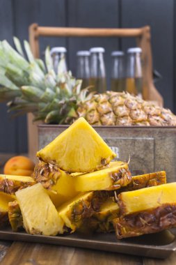 Bir büyük ve olgun ananas parçaları ve bir meyve içine kesilir. Tropikal meyve ahşap arka plan ve piknik için bir spin ile bir kutu. Kopya alanı