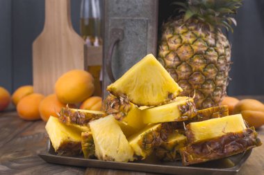 Bir büyük ve olgun ananas parçaları ve bir meyve içine kesilir. Tropikal meyve ahşap arka plan ve piknik için bir spin ile bir kutu. Kopya alanı