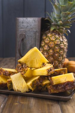 Bir büyük ve olgun ananas parçaları ve bir meyve içine kesilir. Tropikal meyve ahşap arka plan üzerinde. Metin için özgür yer. Kopya alanı,