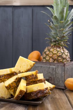 Ananas ve ahşap arka plan üzerinde metal bir kutu şeftali. Vitamin ve detoks yaz aylarında. Vintage Fotoğraf. Polis alanı