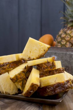 Ananas ve ahşap arka plan üzerinde metal bir kutu şeftali. Vitamin ve detoks yaz aylarında. Vintage Fotoğraf. Polis alanı