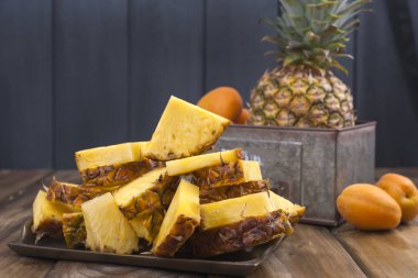 Ananas ve ahşap arka plan üzerinde metal bir kutu şeftali. Vitamin ve detoks yaz aylarında. Vintage Fotoğraf. Polis alanı