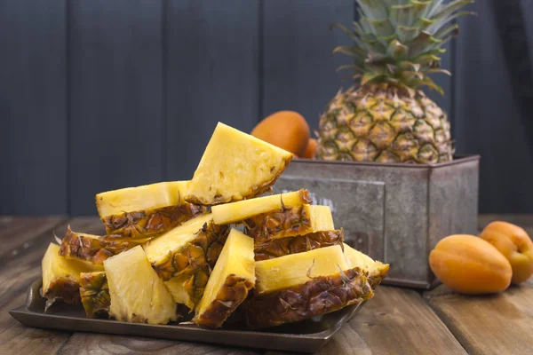 Ananas ve ahşap arka plan üzerinde metal bir kutu şeftali. Vitamin ve detoks yaz aylarında. Vintage Fotoğraf. Polis alanı