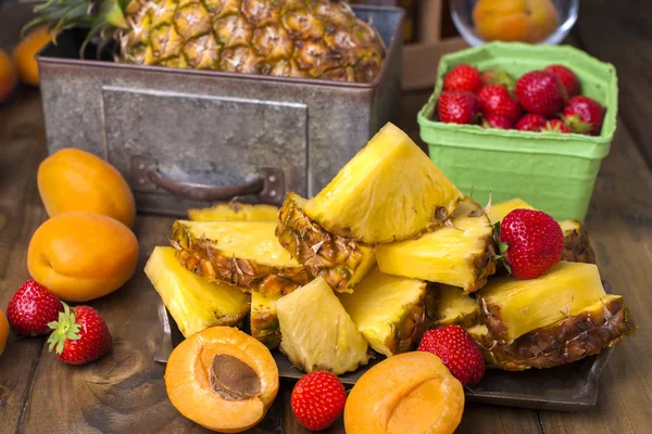 olgunlaşmış tropikal meyve, çilek, şeftali suyu ve kokteyl bir partide. Bir kutu bira ve bir ahşap arka plan. Vintage Fotoğraf.