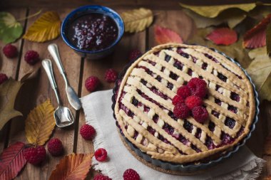 Ahududu ve çilek ile ev yapımı sonbahar pasta. Sonbahar yaprakları ile bir ahşap zemin üzerinde. Kahvaltı için pişirme. Üstten görünüm.