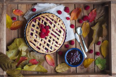 Ahududu ve çilek ile ev yapımı sonbahar pasta. Sonbahar yaprakları ile bir ahşap zemin üzerinde. Kahvaltı için pişirme. Üstten görünüm.
