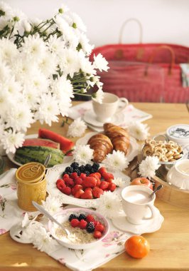 Büyük bir buket beyaz çiçek tablo ve ailesi için kahvaltı. Rahat ev ve lezzetli yemekler. Meyve, hamur işleri ve hoş kokulu kahve. Kopya alanı