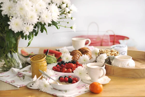 Egy nagy csokor fehér virágot az asztalra, és a reggelit a család. Hangulatos ház, és a finom étel. Gyümölcsöket, süteményeket és illatos kávé. Másolja a hely — Stock Fotó