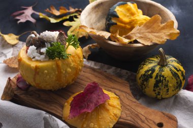 Etli kabak pişmiş. pirinç ve mantar. Delicious sonbahar akşam yemeği. Yapraklarda siyah bir arka plan dekor. Metin için boş alan