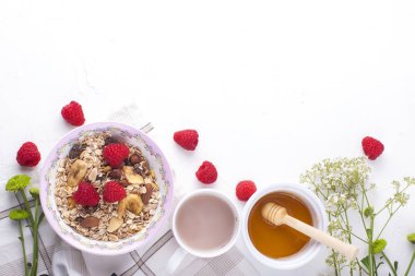 Beyaz bir arka plan üzerinde lezzetli ve sağlıklı bir kahvaltı. Yulaf ezmesi, ahududu, bal, iyi bir sabah kahve yulaf lapası. Metin, en iyi görünüm için boş alan.