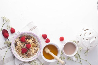 Beyaz bir arka plan üzerinde lezzetli ve sağlıklı bir kahvaltı. Yulaf ezmesi, ahududu, bal, iyi bir sabah kahve yulaf lapası. Metin, en iyi görünüm için boş alan.