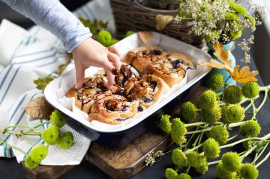 Cinnabon çikolata ile. Yemek pişirme, ev yapımı hamur işleri. Aile kahvaltılar ve çerçeve içinde el. Metin için özgür yer. Üstten görünüm.