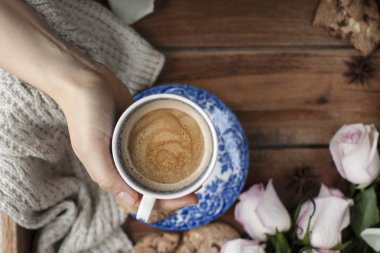 hoş kokulu kahve bir kadının el, beyaz gül ve sonbahar coziness bir buket. Günaydın. üst görünümü. kopya spase