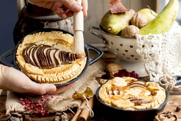 Pie with pear in female hands and autumn decor. . Home comfort and open window. Rustic photo. Delicious homemade pastries for breakfast. Top view. Copy space.
