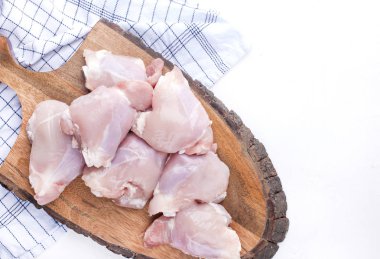 Portakal bir ahşap tahta ve beyaz masa üzerinde ham ile tavuk. Lezzetli bir etli yemek hazırlanması. Üstten görünüm.