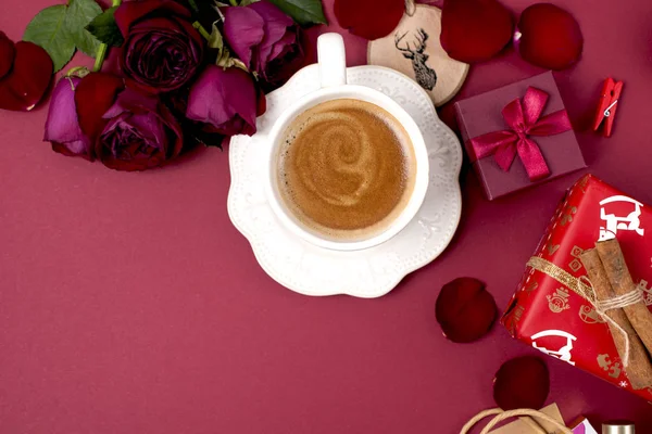 Une tasse de café parfumé et décor du Nouvel An sur un fond rouge. roses, cadeaux et surprises de Noël. Vue de dessus. Cadre. copie spase — Photo