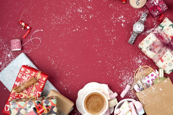 Eine Tasse duftenden Kaffees und Neujahrsdekor auf rotem Hintergrund. Geschenke und syootrizy für Weihnachten. Ansicht von oben. Rahmen. Kopierraum — Stockfoto
