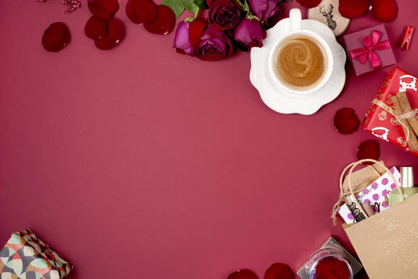 Una taza de café fragante y decoración de Año Nuevo sobre un fondo rojo. rosas, regalos y sorpresas navideñas. Vista superior. Una trampa. spase de copia — Foto de Stock