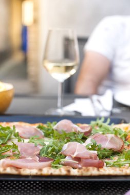 Roka ve jambon İtalyan pizza. Lezzetli bir geleneksel yemek yemek ve bir kadeh beyaz şarap için. Homemade Pişirme. Üstten görünüm.