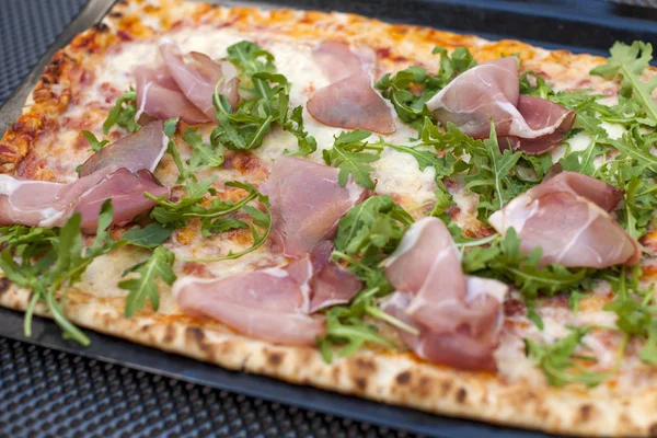 Italiaanse pizza met rucola en ham. Heerlijke traditionele gerechten voor de lunch. Homemade bakken. Bovenaanzicht. Kopiëren van ruimte — Stockfoto