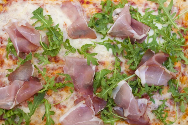 Italian pizza with arugula and ham. Delicious traditional food for lunch. Homemade baking. Top view. Copy space — Stock Photo, Image