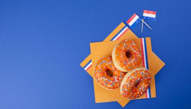 Turuncu donuts Kings gün, Hollanda tatil tatil için. Mavi bir arka plan üzerinde pişirme. Üstten görünüm. Kopya alanı.