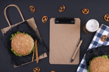 Öğle yemeği için siyah bir zemin üzerine iki hamburger. Ofis ve okul gıda. Üstten görünüm. Metin için özgür yer. Düz yatıyordu.