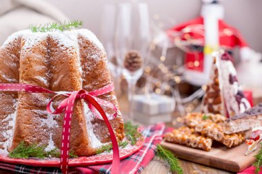 Geleneksel İtalyan Noel meyve Panettone Pandoro Festival kırmızı kurdele ve fındık ve Nuga tatlılar ile pasta. Ahşap bir arka plan üzerinde. Metin için boş alan