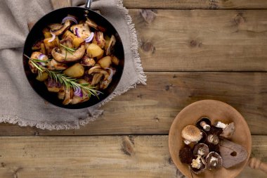 Siyah bir dökme demir patates kızartması bir ahşap arka plan üzerinde pan. Vintage Fotoğraf ve peçete rustik tarzda. Metin, en iyi görünüm için boş alan.