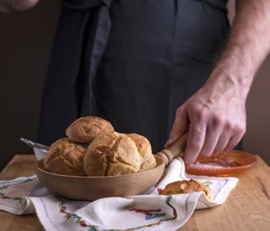 Siyah önlüklü bir adam ev yapımı pastaları tatlı bir şekilde hazırlar. Çörekler...