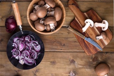 Şampiyon mantarları, yağmalama hasırları ve ahşap arka planda baharatlar. Ahşap tabaklar. Kır tarzında bir fotoğraf. Mesaj için yer. Yemek pişirme kavramı