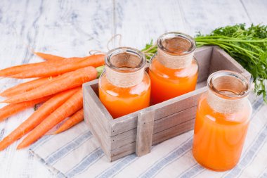 Kavanozda taze havuç suyu. Yapraklı taze havuç ve içecek. Sağlık ve güzellik için bahar yiyeceği. Metin için boş alan