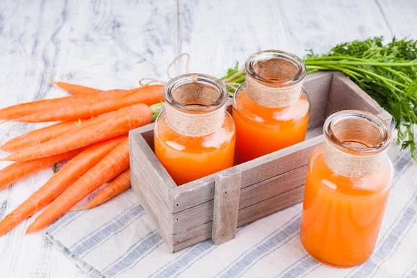 Kavanozda taze havuç suyu. Yapraklı taze havuç ve içecek. Sağlık ve güzellik için bahar yiyeceği. Metin için boş alan