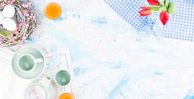 Küçük mavi bir vazoda bir buket lale, çaydanlık ve fincanlar...