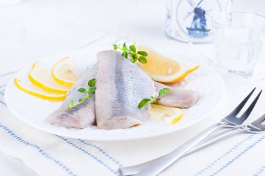 Limon ve soğan ile beyaz bir plaka üzerinde Marine ringa balığı filetosu. Tablo ve Hollanda'nın geleneksel bahar incelik yaptı. Hollanda'da tipik Balık Pişirme. Metin için boş alan.