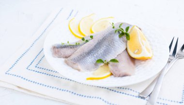Limon ve soğan ile beyaz bir plaka üzerinde Marine ringa balığı filetosu. Hollanda'nın geleneksel bahar incelik. Hollanda'da tipik Balık Pişirme. Metin veya marka için boş alan.