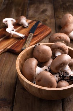 Şampiyon mantarları, yağmalama hasırları ve ahşap arka planda baharatlar. Ahşap tabaklar. Kır tarzında bir fotoğraf. Mesaj için yer. Köy fotoğrafı konsepti.