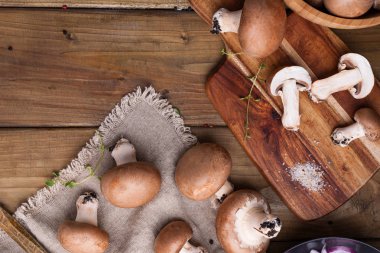 Şampiyon mantarları, yağmalama hasırları ve ahşap arka planda baharatlar. Ahşap tabaklar. Kır tarzında bir fotoğraf. Metin için yer