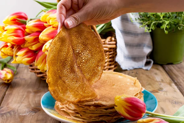 Lots of thin pancakes on a wooden background or table, and a bas — Stock Photo, Image