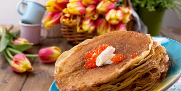 Pancake dengan kaviar dan mentega, karangan bunga tulip segar dan — Stok Foto