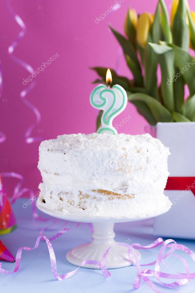Celebratory cake with white cream for birthday and flowers, on a