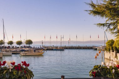 Gölde ya da denizde kırmızı-sarı güneşli bir gün batımı. Gökyüzü, kıyı, güneş ve