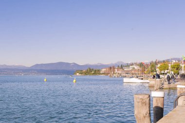 Gölde ya da denizde kırmızı-sarı güneşli bir gün batımı. Gökyüzü, kıyı, güneş ve