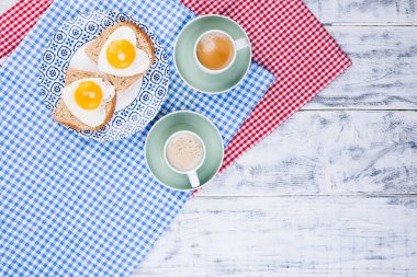 Tabakta kalp şeklinde yumurta ve iki fincan kahveyle tost. R