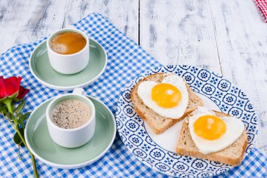 Romantizm için iki fincan aromatik kahve ve kalp şeklinde tost.